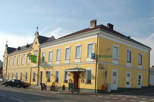 Yellow pub on a street corner with several windows and an entrance.