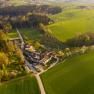 Aerial view of a resort surrounded by green fields and forests.
