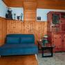 Cozy room with wooden walls, a blue sofa, a wooden table and a rustic wardrobe.