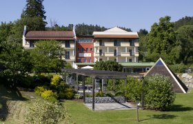 Exterior view of a hotel with garden and pavilion.