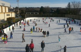 People ice skating on an open-air ice rink in Wolkersdorf.