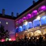 Concert in the arcade courtyard of the Kunsthaus Horn at night with colorful lighting.