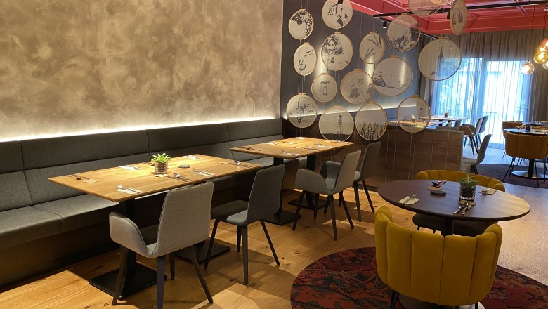 Modern restaurant with stylish furnishings and decorative elements on the wall.