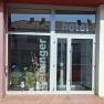 Entrance to the Hotel Deininger with glass front and plants.