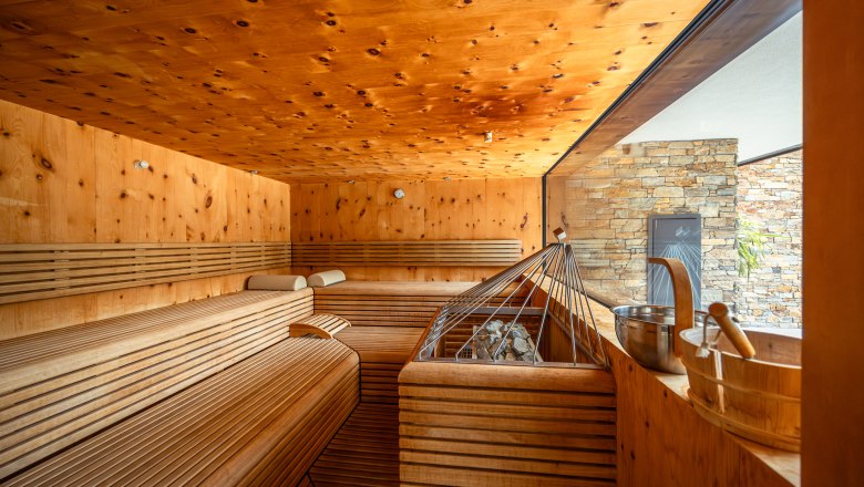 Interior view of a modern sauna with wooden benches and a large window.