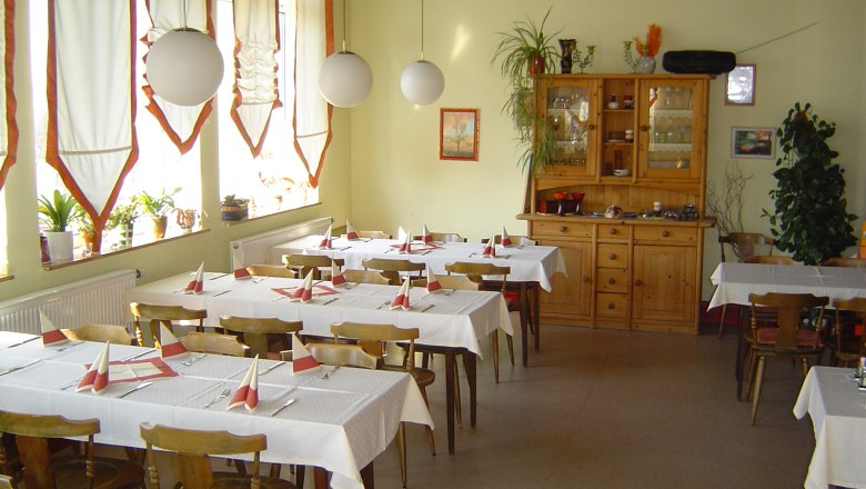 Interior view of a cozy caf&eacute; with wooden furniture and decorated tables.