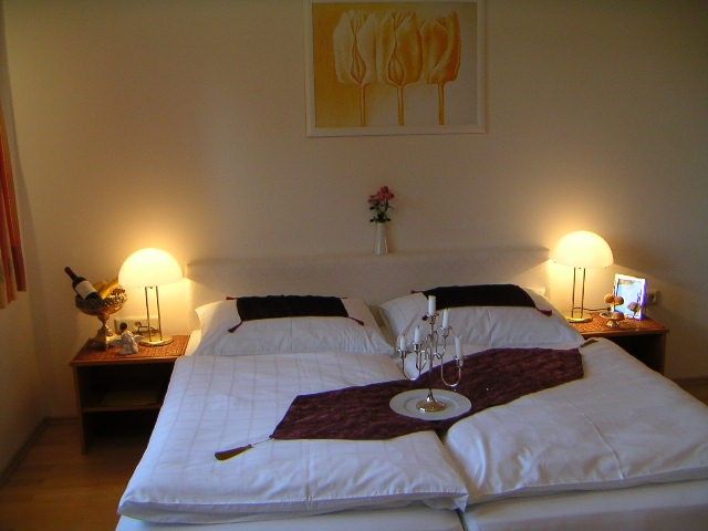 Cozy bedroom with double bed, bedside tables and lamps.