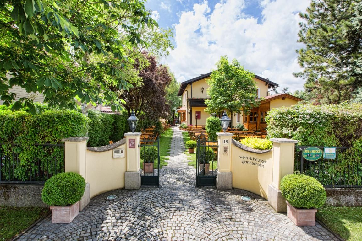 Entrance to a cozy inn with garden and outdoor seating.