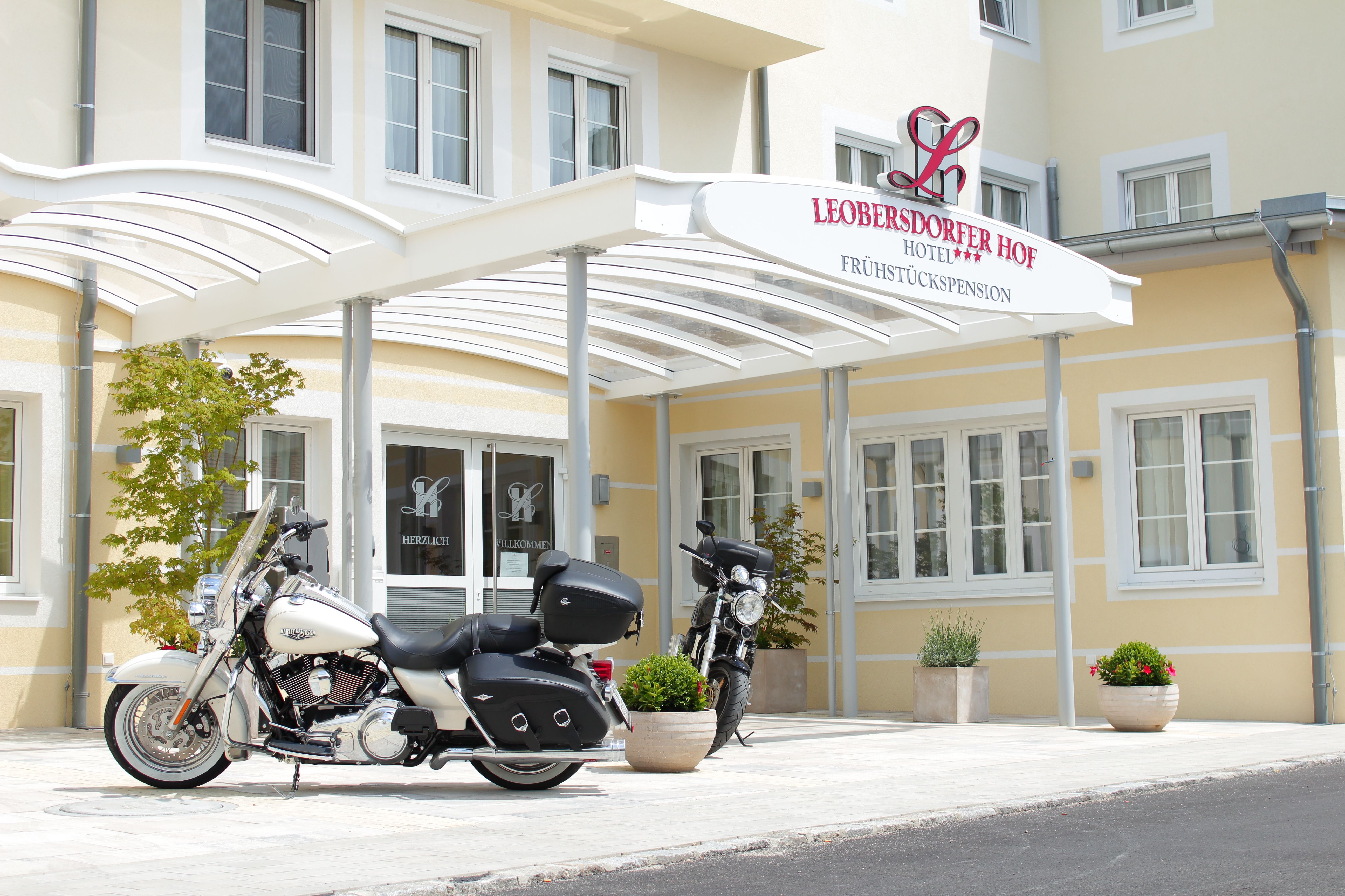 Two motorcycles in front of the entrance to the Leobersdorfer Hof Hotel.