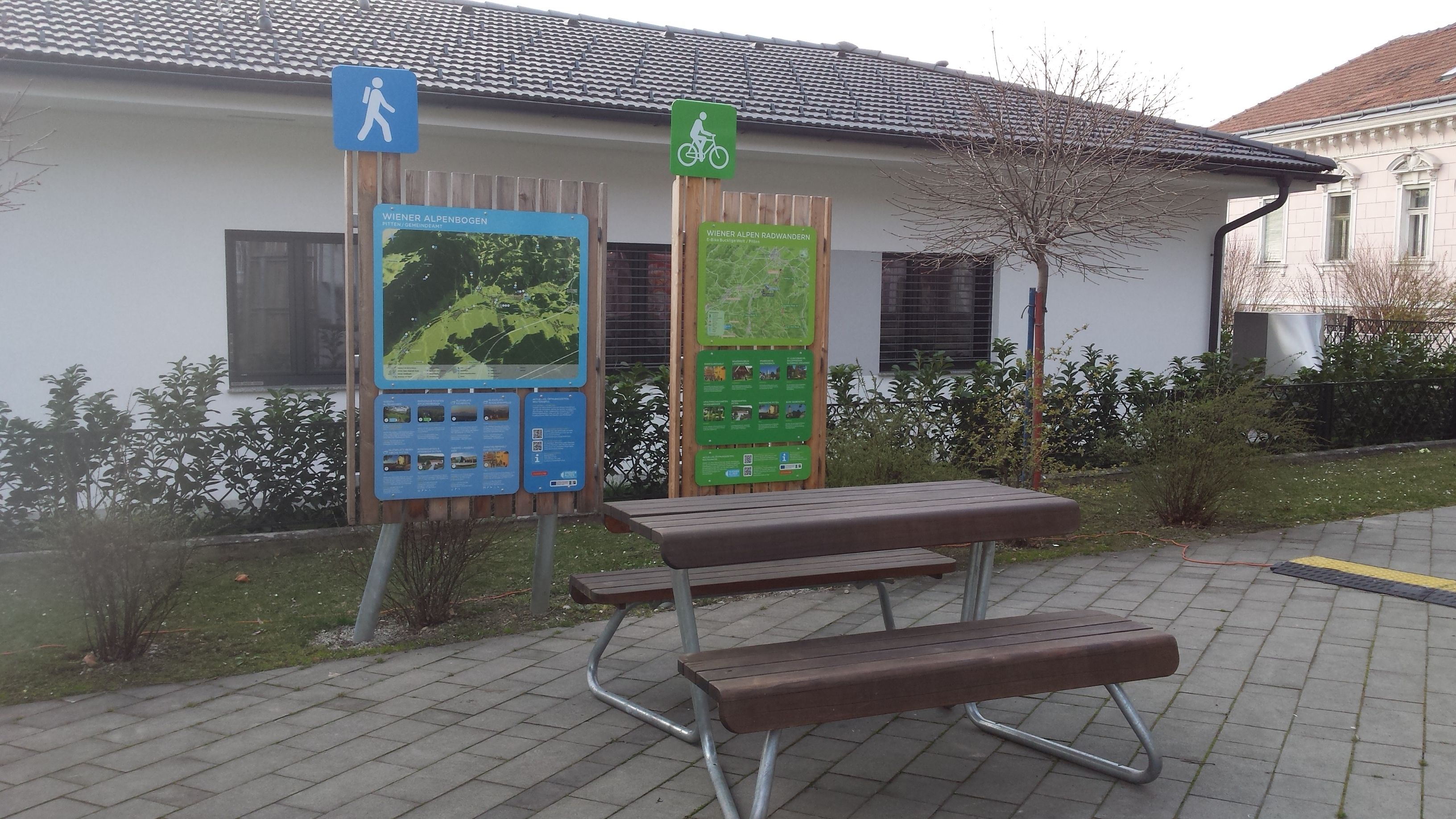 A rest area with information boards for hikers and cyclists in Pitten.