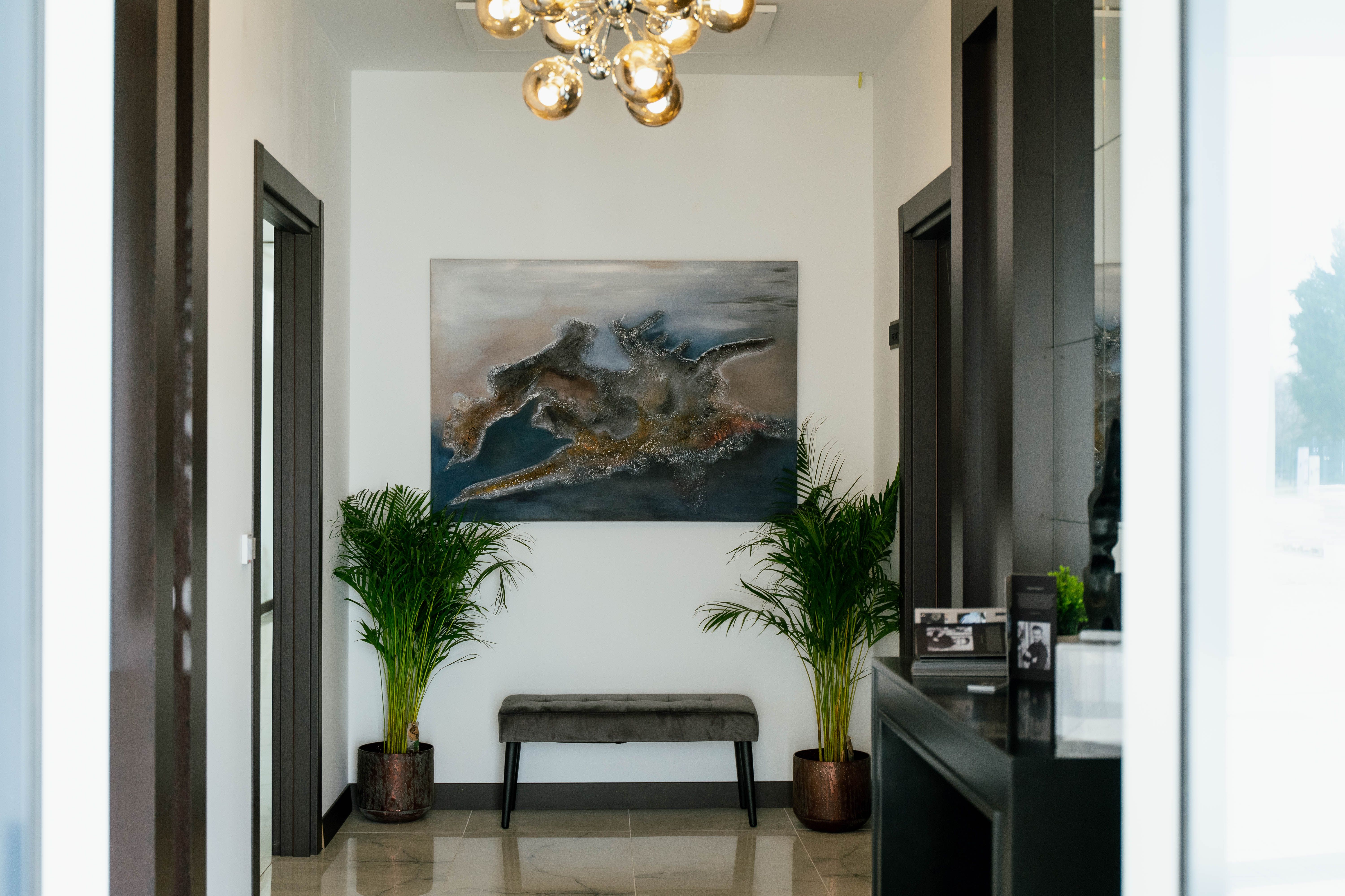 Modern hotel corridor with artwork and plants.