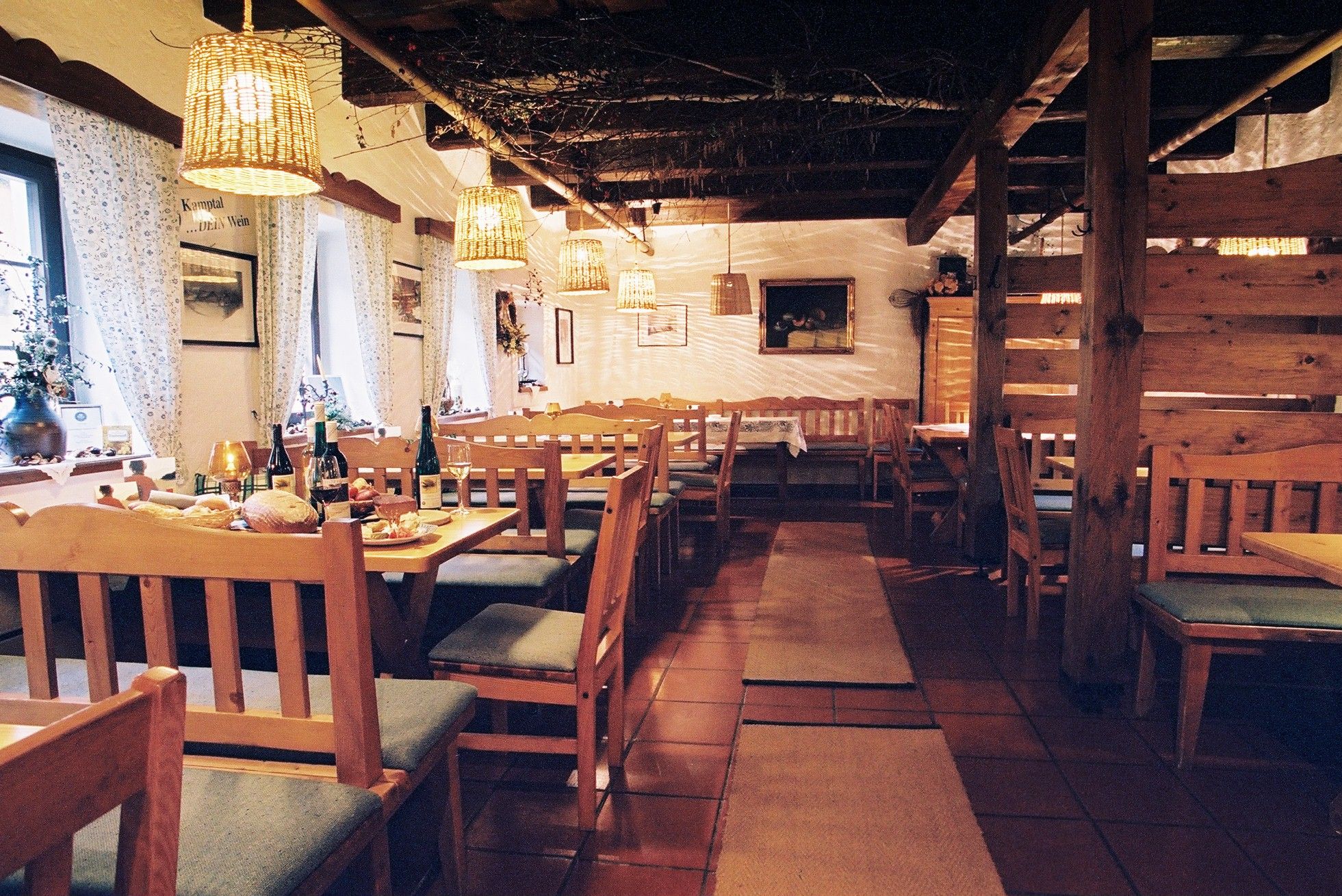 Cozy interior of a traditional wine tavern with wooden furniture and laid tables.