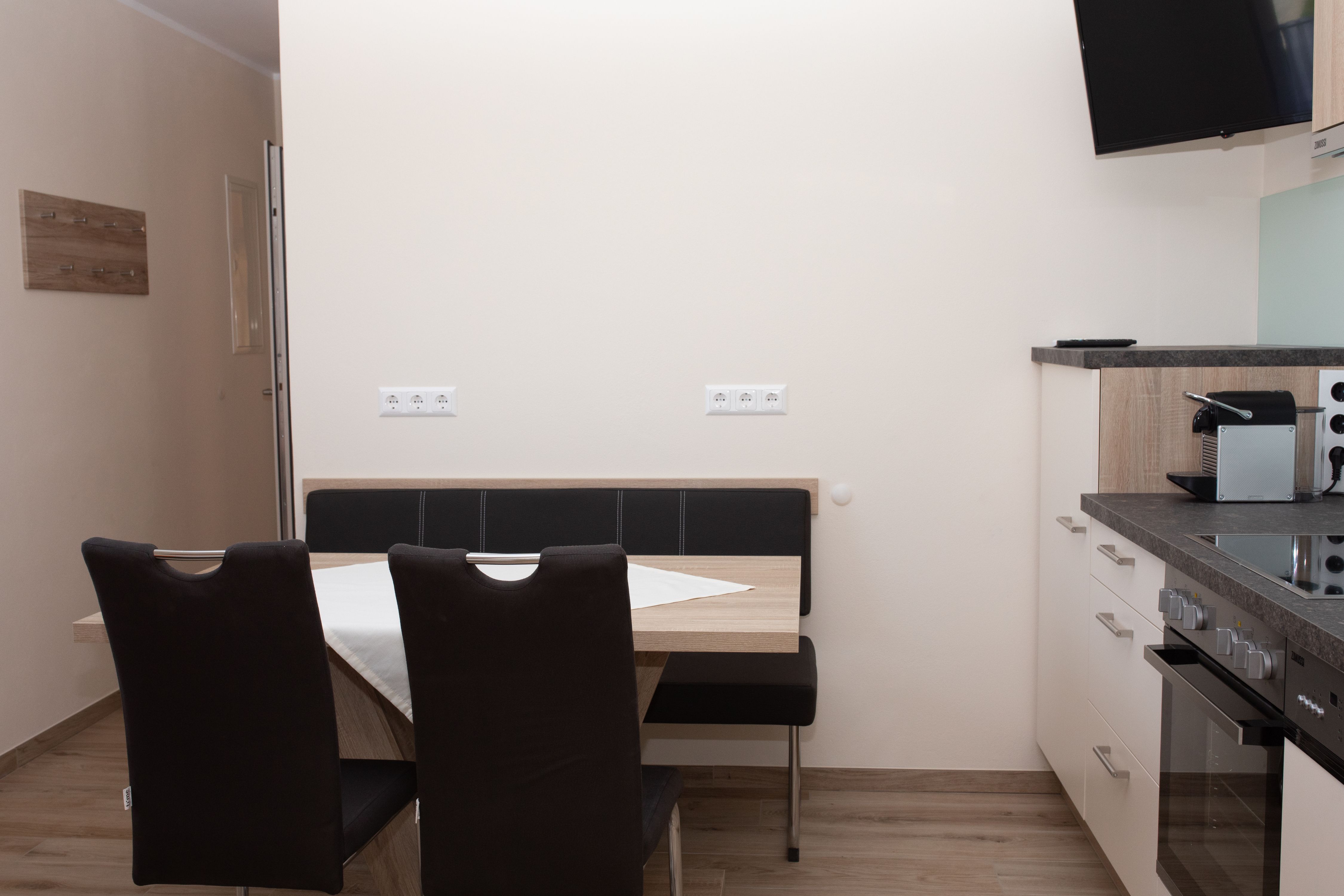 Dining area with table, chairs and kitchenette.