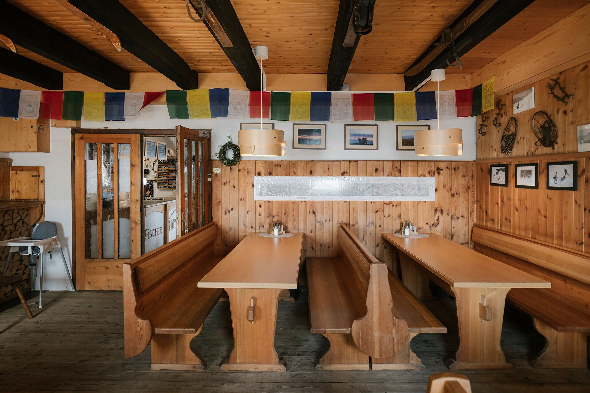 Cozy dining room at the Fischerhütte on Schneeberg, featuring wooden tables, benches, and traditional decor