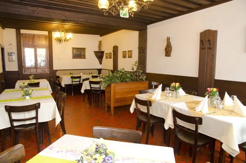 Interior view of a traditional restaurant with wooden furniture and decorated tables.