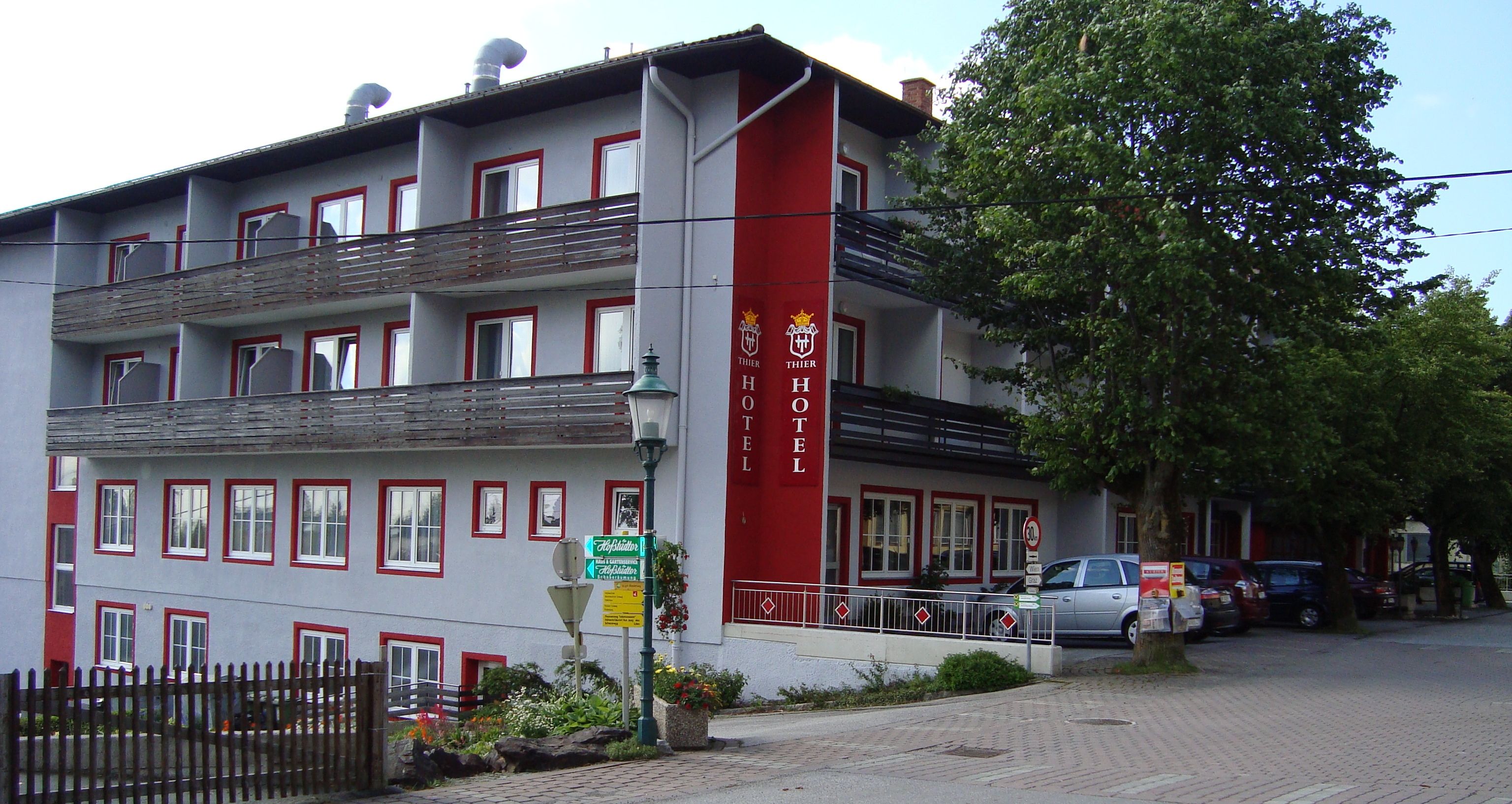 Exterior view of the Hotel Thier with balconies and red lettering.