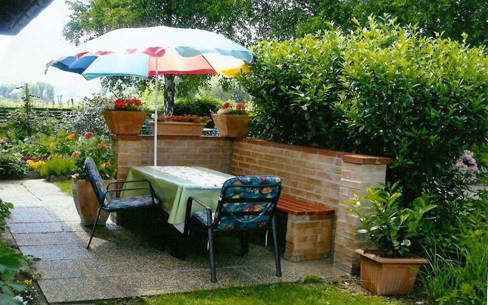Garden with table, chairs and parasol.
