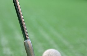 Minigolf clubs in front of green grass