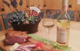 A table with ham, wine and decoration.