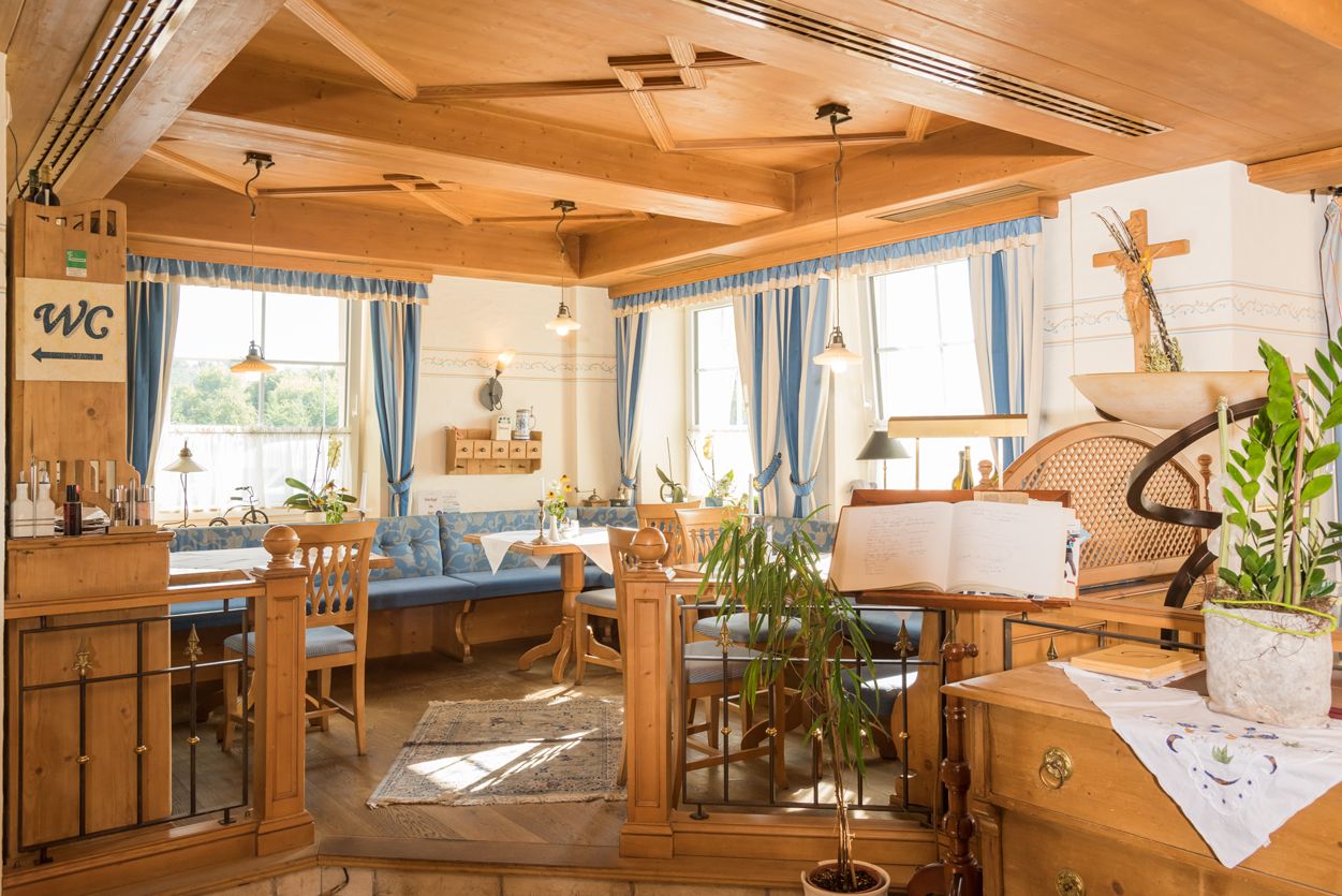 Cozy restaurant area with wooden furniture and blue curtains.