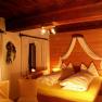Cozy bedroom with wooden walls and yellow bed linen.