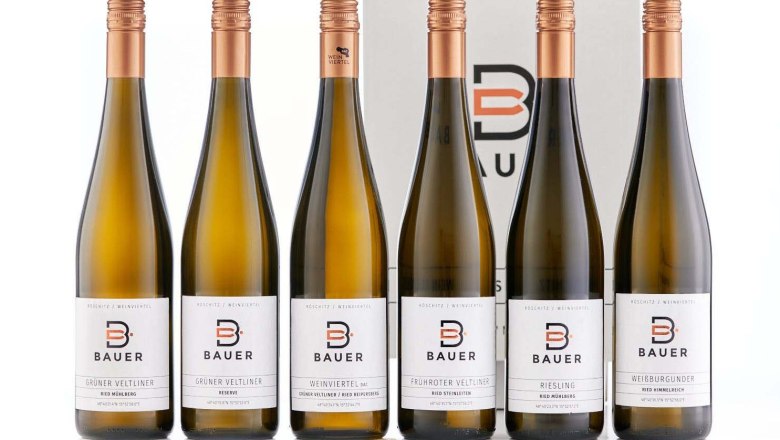 Six Bauer brand wine bottles in front of a box.