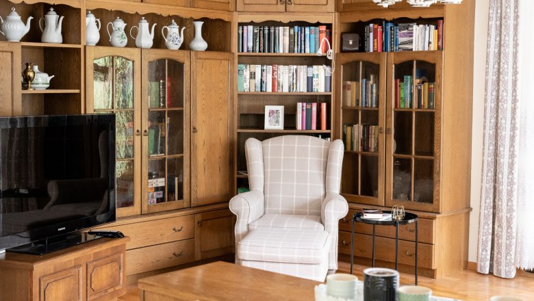Living room with bookshelf, armchair and TV.