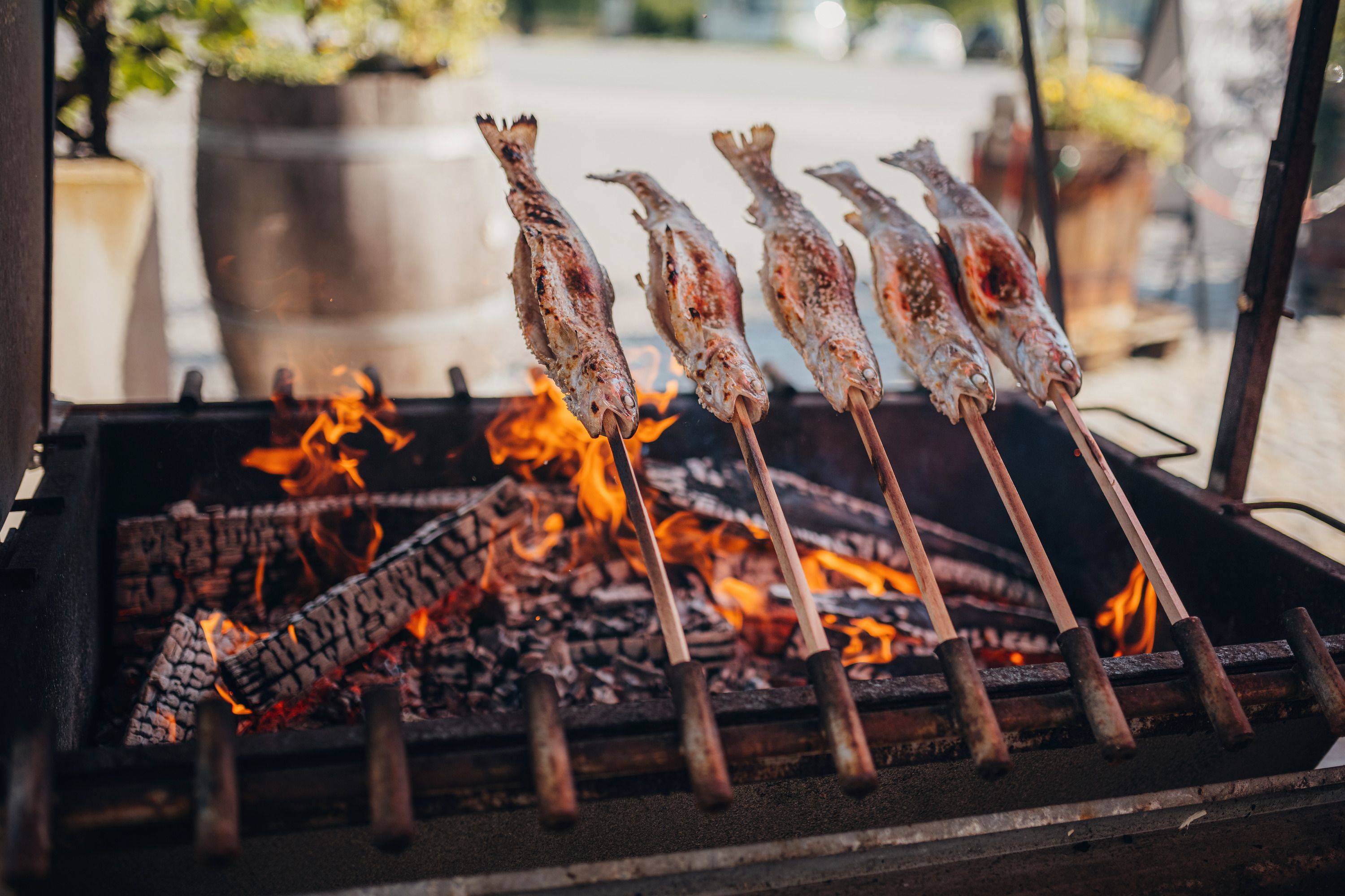 Steckerlfisch grilled over an open fire, traditional preparation.