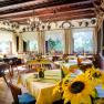 Cozy dining room with wooden furniture, yellow tablecloths and sunflowers.