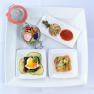 An elegant starter plate with various small dishes on a white plate.