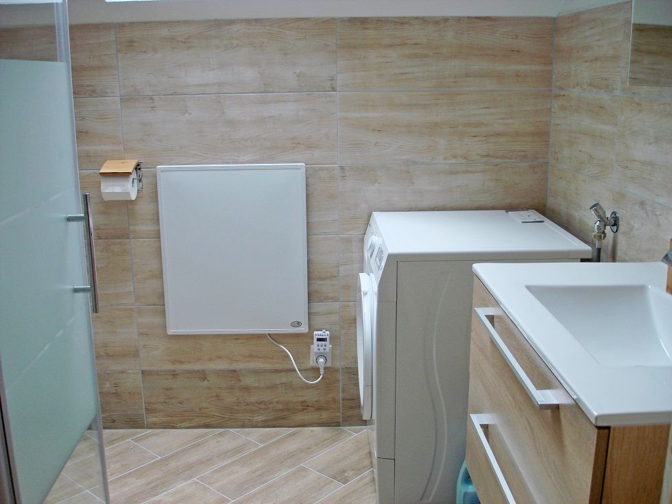 Modern bathroom with washing machine and washbasin.