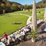 Terrace of the seminar and event hotel Krainerh&uuml;tte with guests eating, surrounded by green meadows and forest.