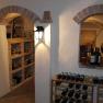 A wine cellar with bottle racks and brick arches.