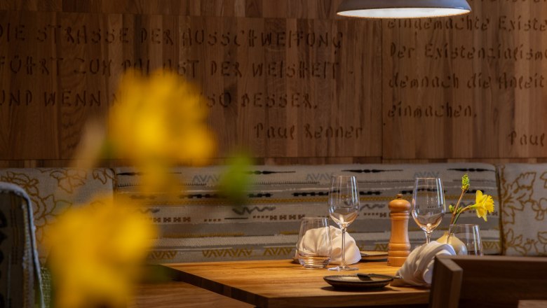 Comfortably set table in a restaurant with wooden walls and hanging lamp.
