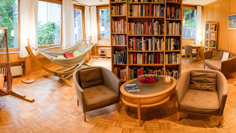 Cozy library with hammocks, armchairs and bookshelves in a hotel.