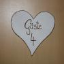 Wooden sign in the shape of a heart with the inscription 'Gäste 4'.