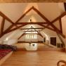 A bright seminar room with wooden beams, wooden floor and comfortable seating.