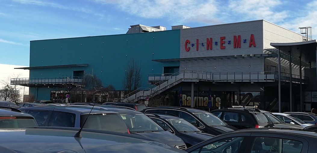 Exterior view of the Cinemaplexx Krems with parked cars in the foreground.