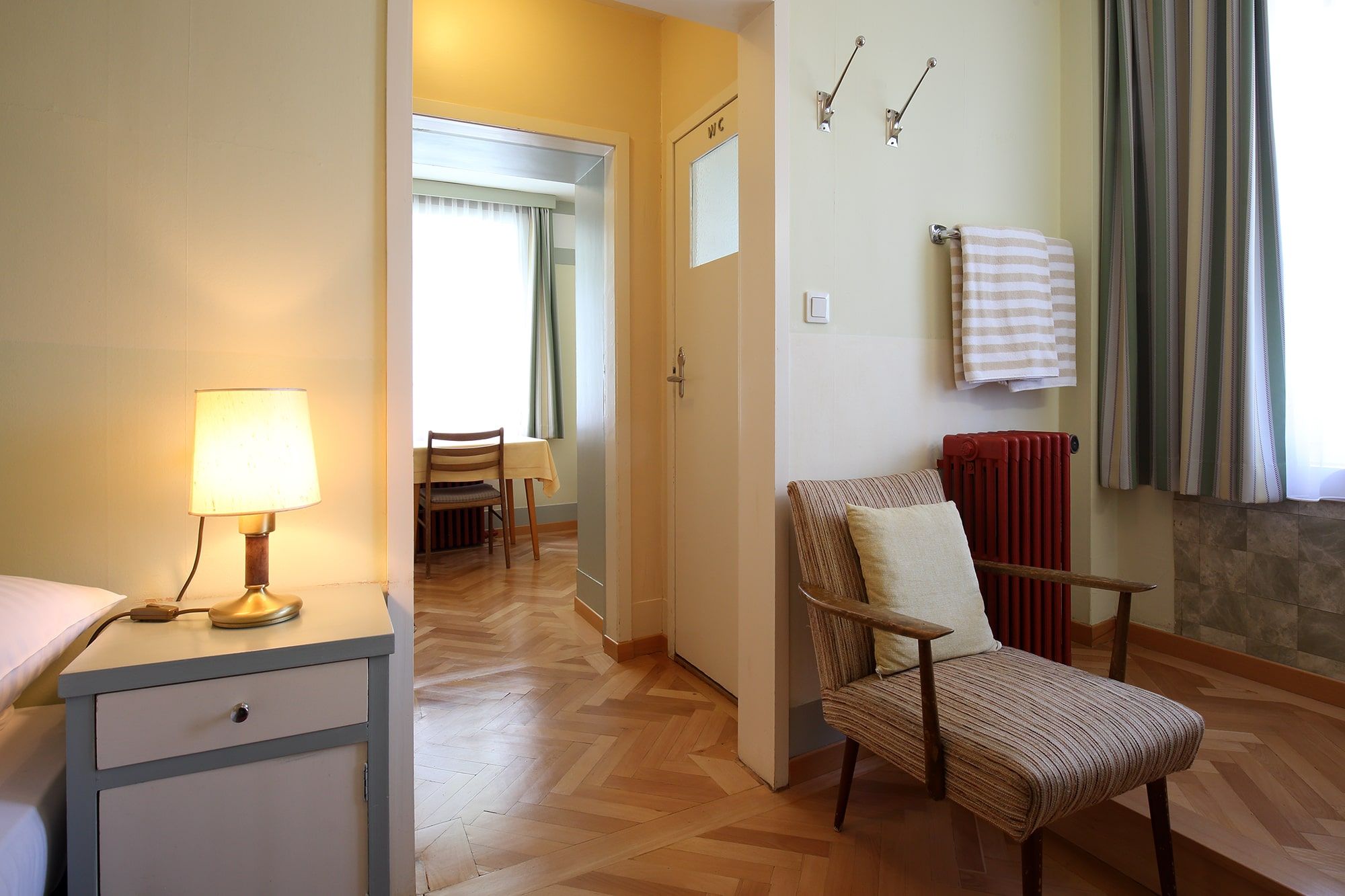 Interior view of a room in the Looshaus with armchair, bedside lamp and table in the background.