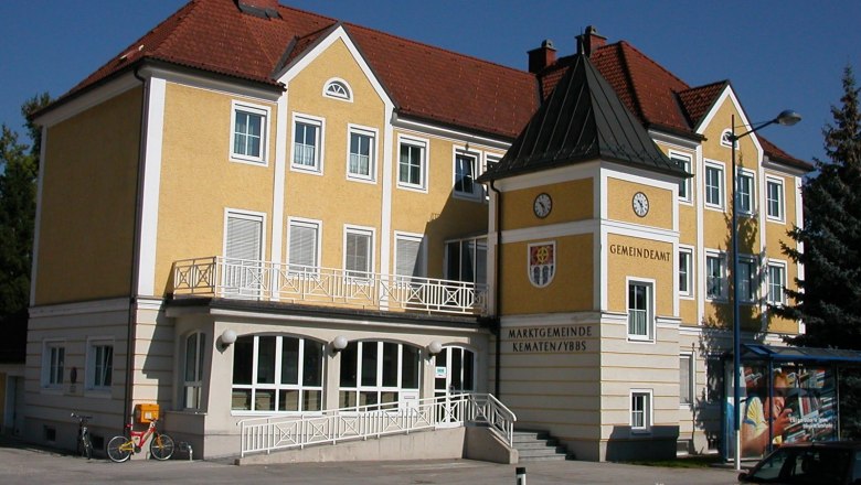 Yellow building of the Kematen an der Ybbs municipal office with clock and coat of arms.