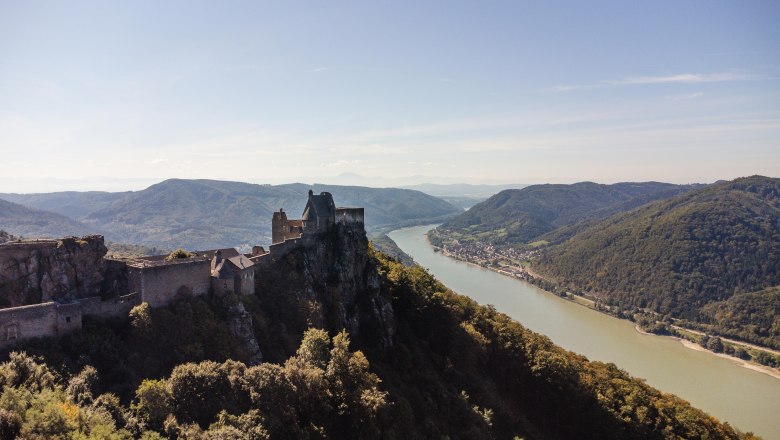 Aerial view of the Aggstein castle ruins with a view of the Danube and surrounding hills.
