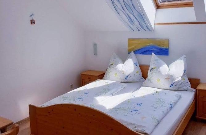 Bright bedroom with wooden bed, skylight and blue decoration.