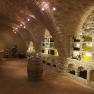 Wine cellar with brick vaults and wine bottles on shelves.