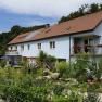 Exterior view of a blue guest house with garden and playground.