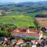 Aerial view of Seitenstetten Benedictine Abbey surrounded by green fields and hills.