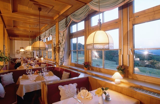 Cozy restaurant with wooden furnishings and large windows overlooking the countryside.