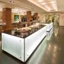 Modern buffet in a hotel restaurant with illuminated counters and various dishes.