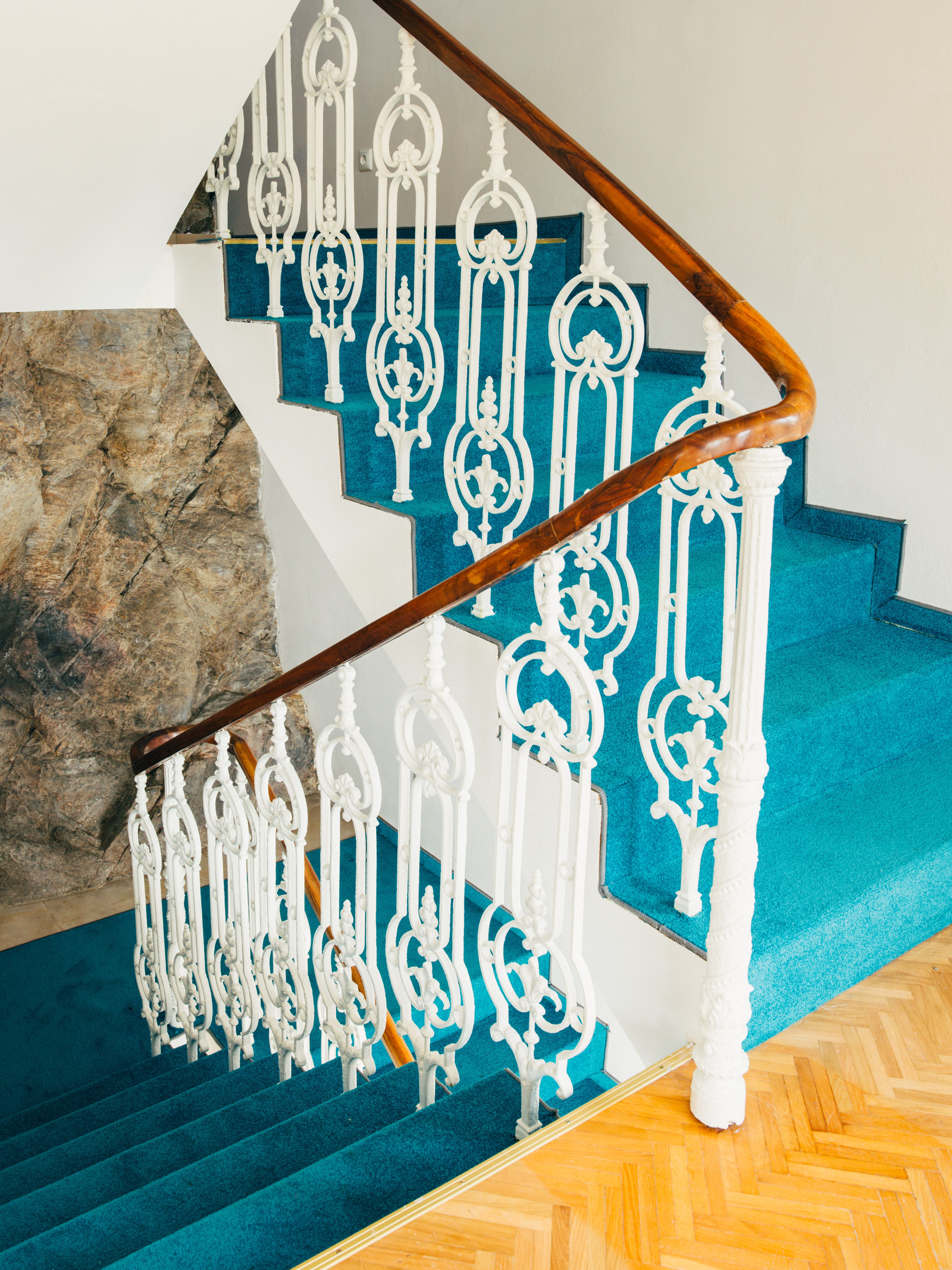 Staircase with blue carpet and white banister.