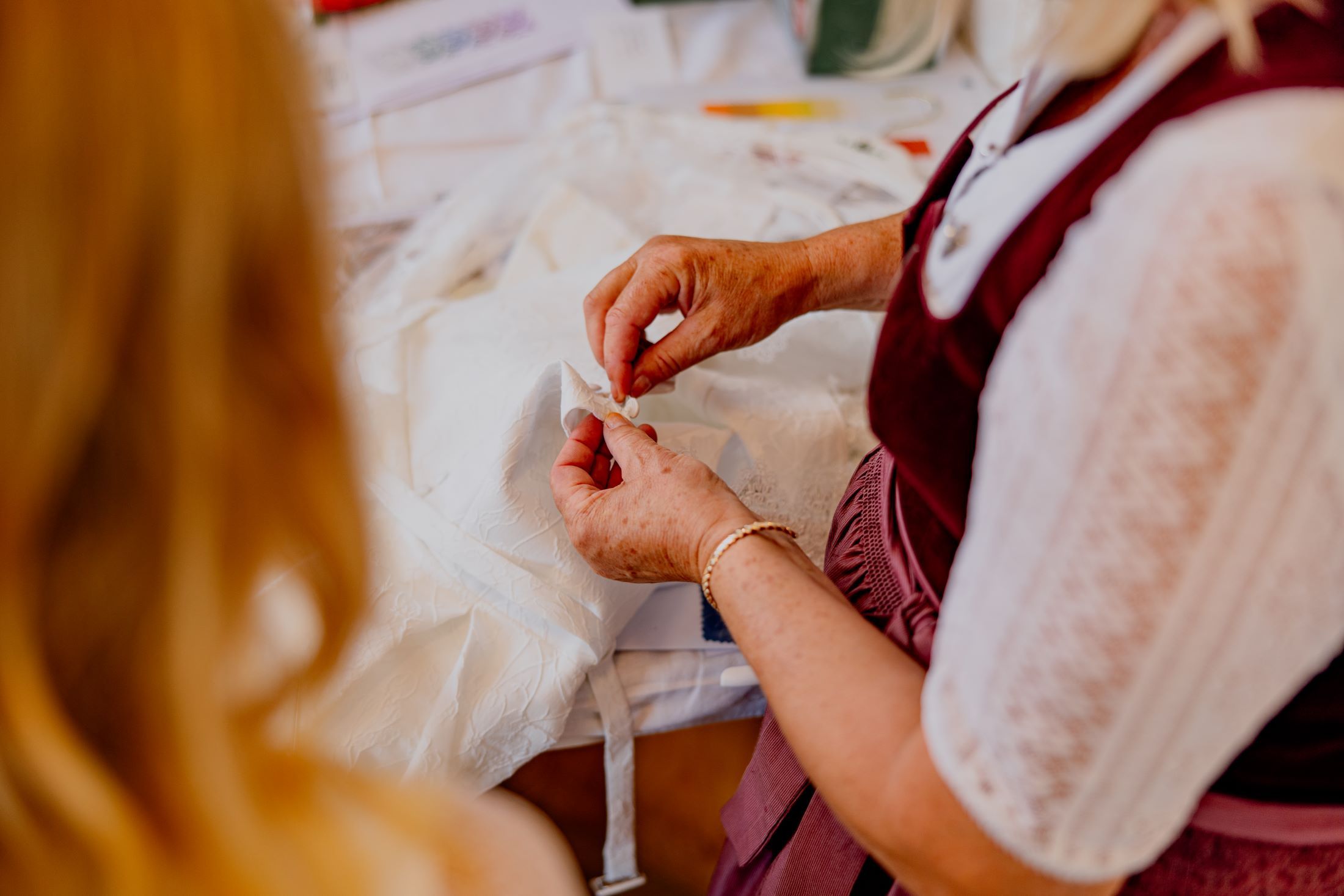 Close-up of a person working on a white fabric.