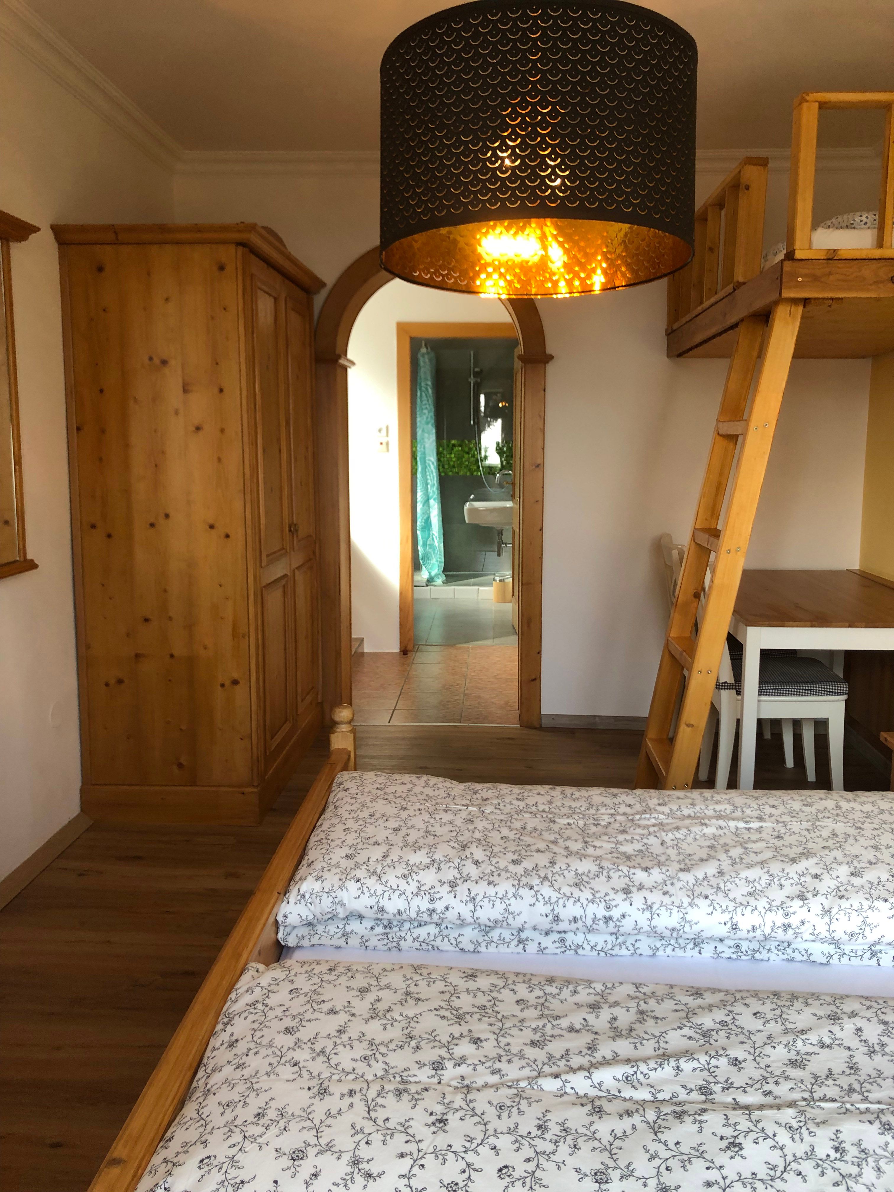 Interior view of a room with wooden furniture and a passageway to a bathroom.